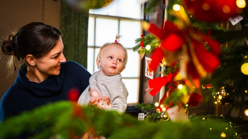A mother and child admire a Christmas tree in Wimpole Hall, at Wimpole Estate, Cambridgeshire